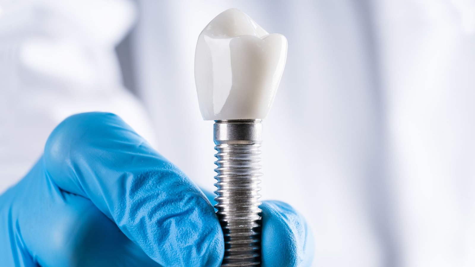 A hand holding a dental implant